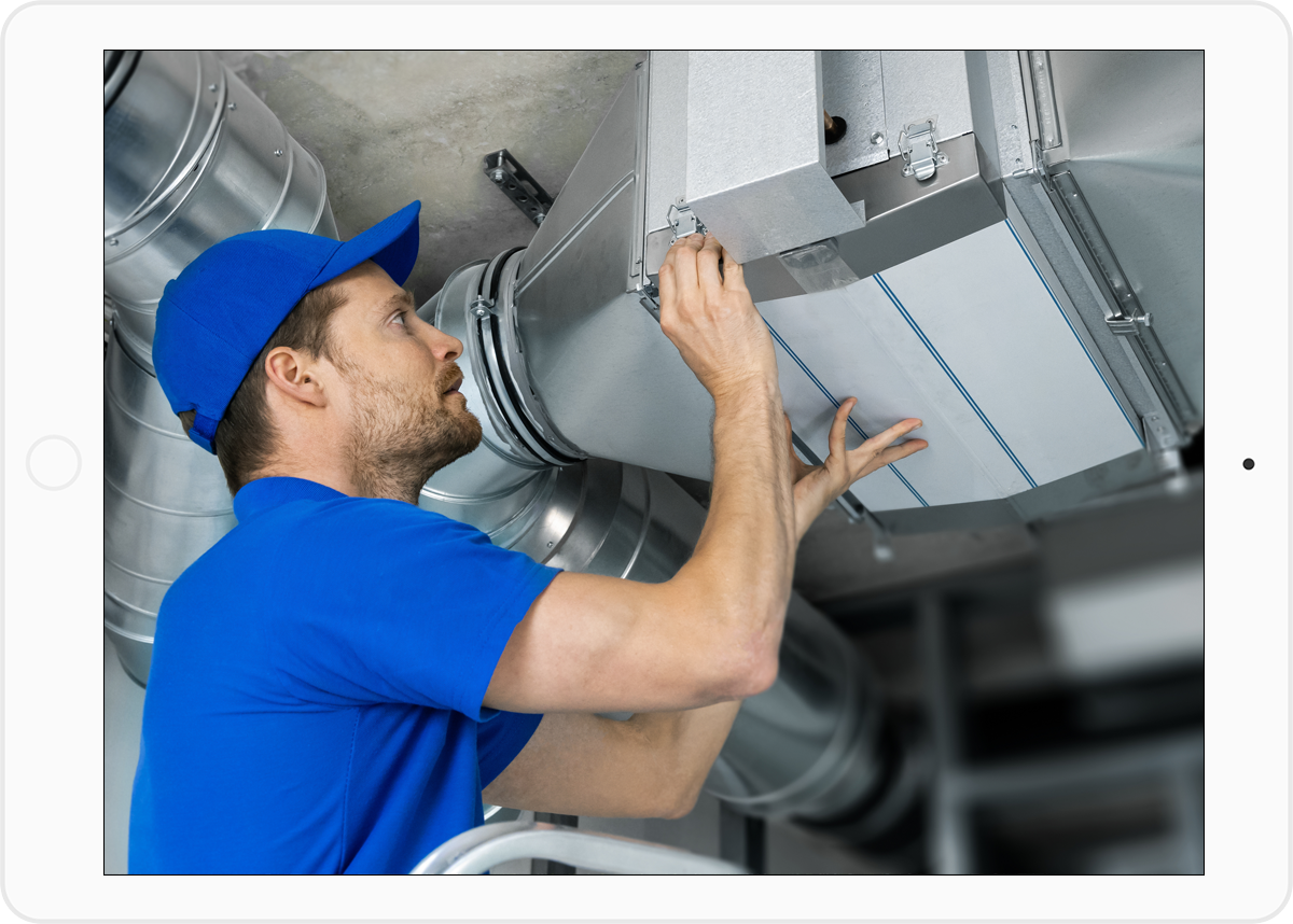 Technicien manipulant une gaine isolée pour un système de chauffage gainable